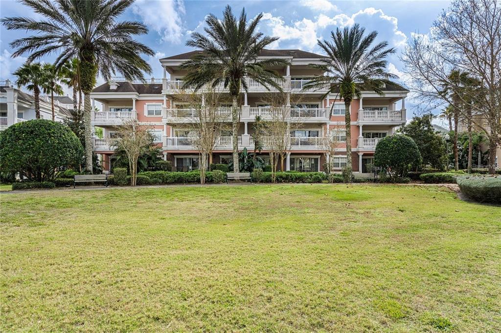 A dining area with a glass-topped table and a living room with wood-look flooring — 1102 SUNSET VIEW CIRCLE UNIT 204, REUNION, FL