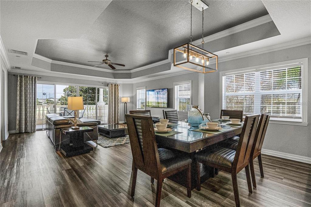 A living room features a tray ceiling, a sectional sofa, and sliding doors to a balcony — 1102 SUNSET VIEW CIRCLE UNIT 204, REUNION, FL