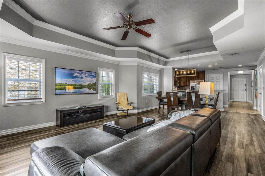 A dining area with a wooden table and chairs sits adjacent to an open kitchen — 1102 SUNSET VIEW CIRCLE UNIT 204, REUNION, FL