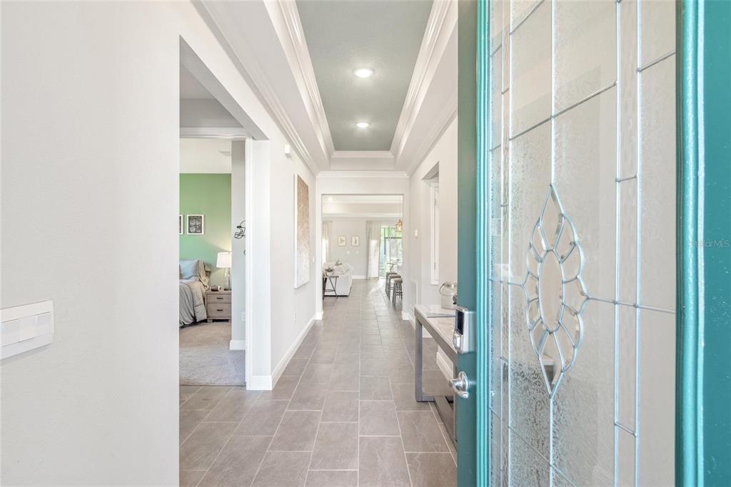A view from an entryway looking down a tiled hallway toward a living area — 2214 ELEGANT MANOR CIRCLE, EDGEWATER, FL