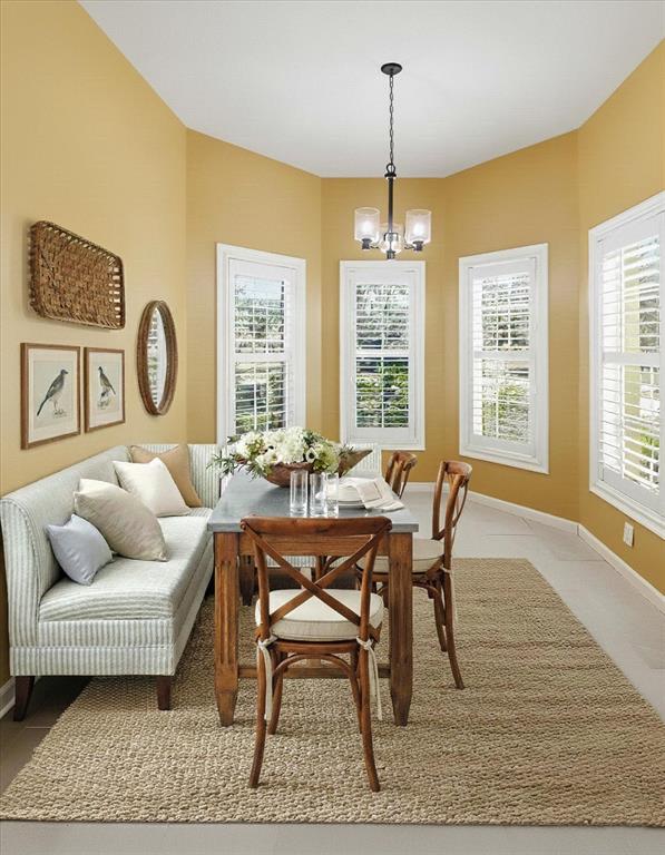 A dining room features a striped banquette, wooden chairs, a rectangular table, and yellow walls — 6301 W GLYNBORNE LOOP, CRYSTAL RIVER, FL