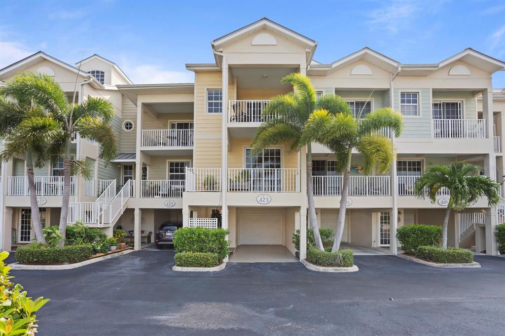 A multi-story residential building with balconies, palm trees, and ground-level garages — 423 BAHIA BEACH BOULEVARD, RUSKIN, FL