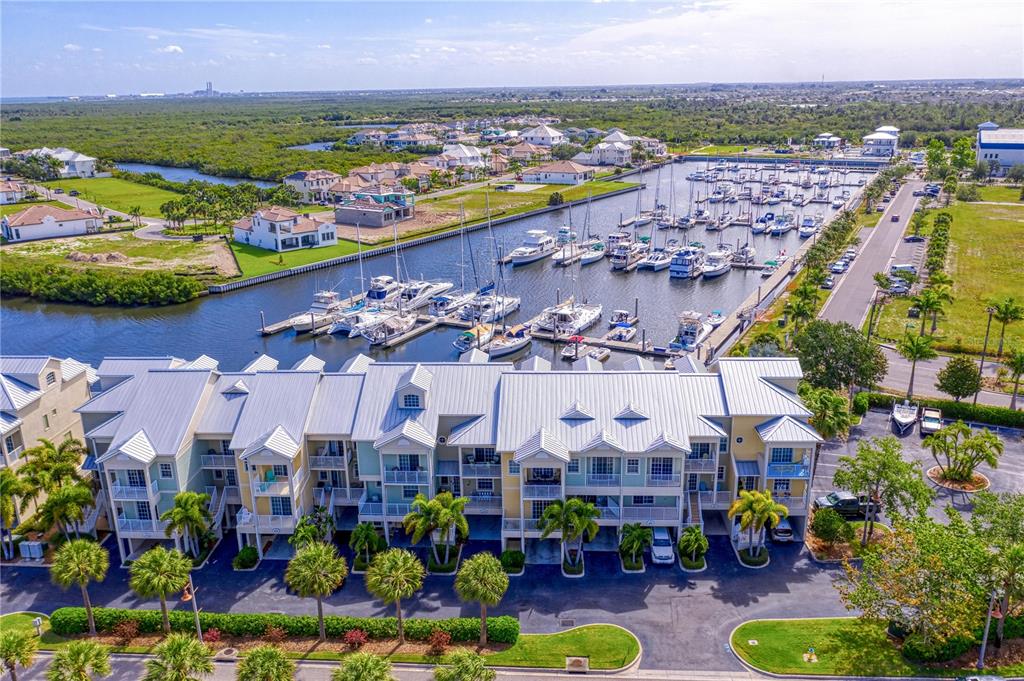 An aerial view shows a multi-story townhouse complex situated next to a boat-filled marina — 423 BAHIA BEACH BOULEVARD, RUSKIN, FL