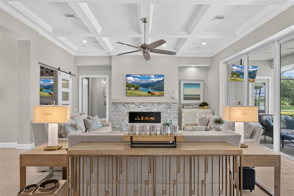 A living room features a stone fireplace, coffered ceiling, and a console table behind a sofa — 55 OCEAN OAKS LANE, PALM COAST, FL
