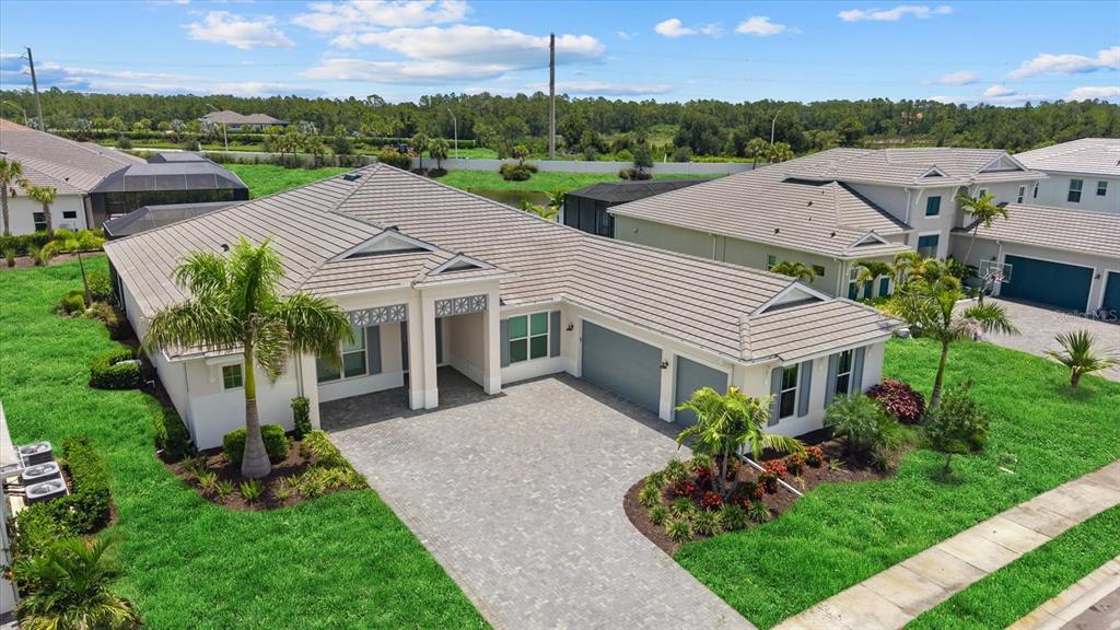 An aerial view of a suburban house with a paved driveway and a tiled roof — 8133 NEVIS RUN, LAKEWOOD RANCH, FL