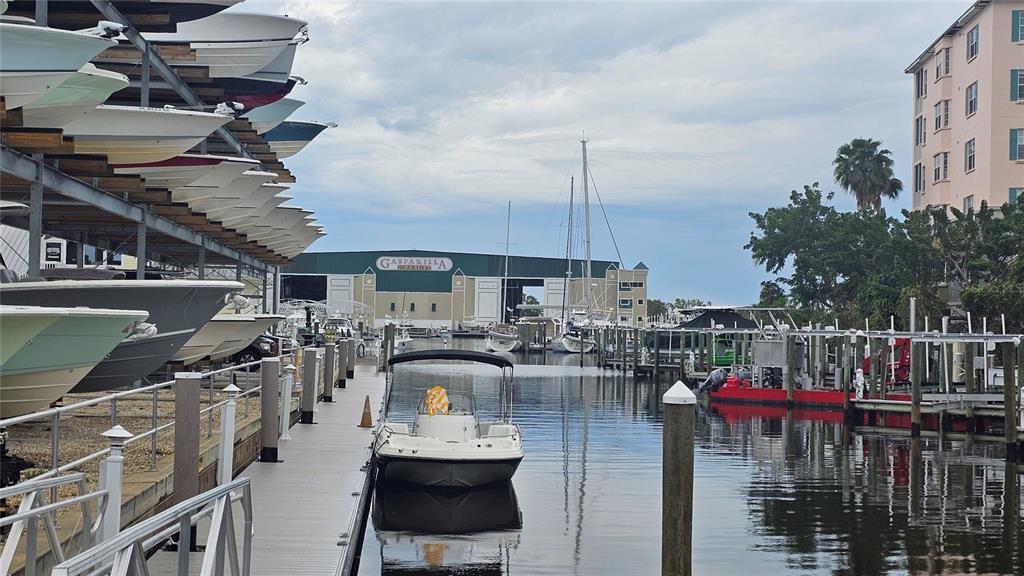 A marina features a boat storage rack, a floating dock, and several boats in water — 12043 BACCHUS ROAD, PORT CHARLOTTE, FL