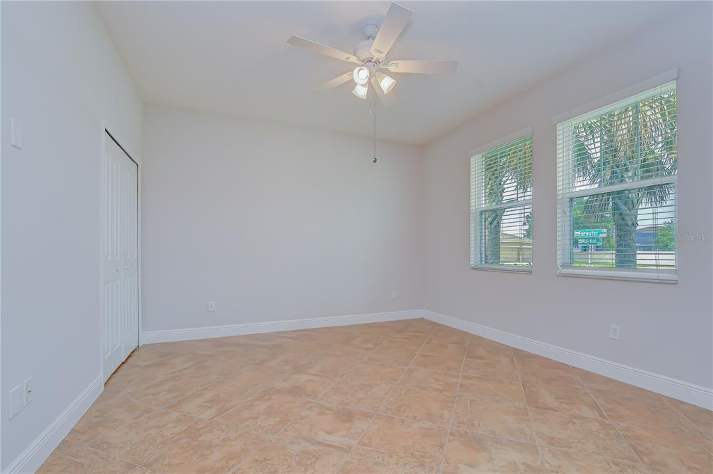 An empty room features light-colored walls, tile flooring, a ceiling fan, and two windows — 6622 FAIRWATER DRIVE, RIVERVIEW, FL
