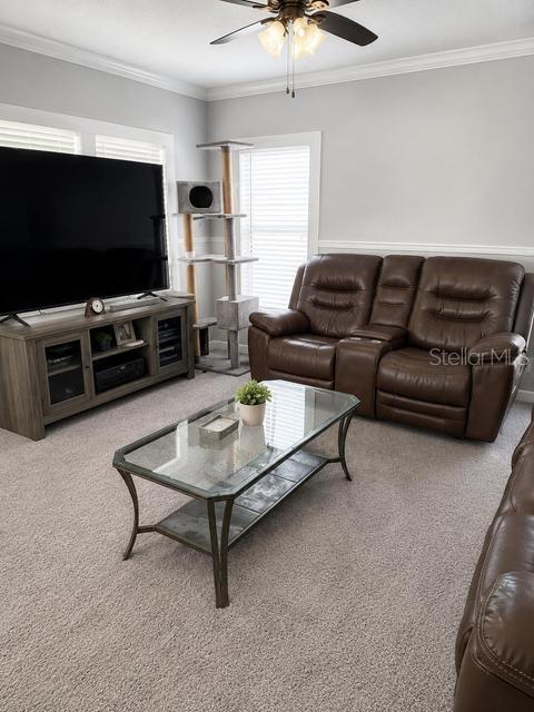 A living room features a brown leather loveseat, a glass coffee table, and a television console — 56 MANOR DRIVE, FORT PIERCE, FL