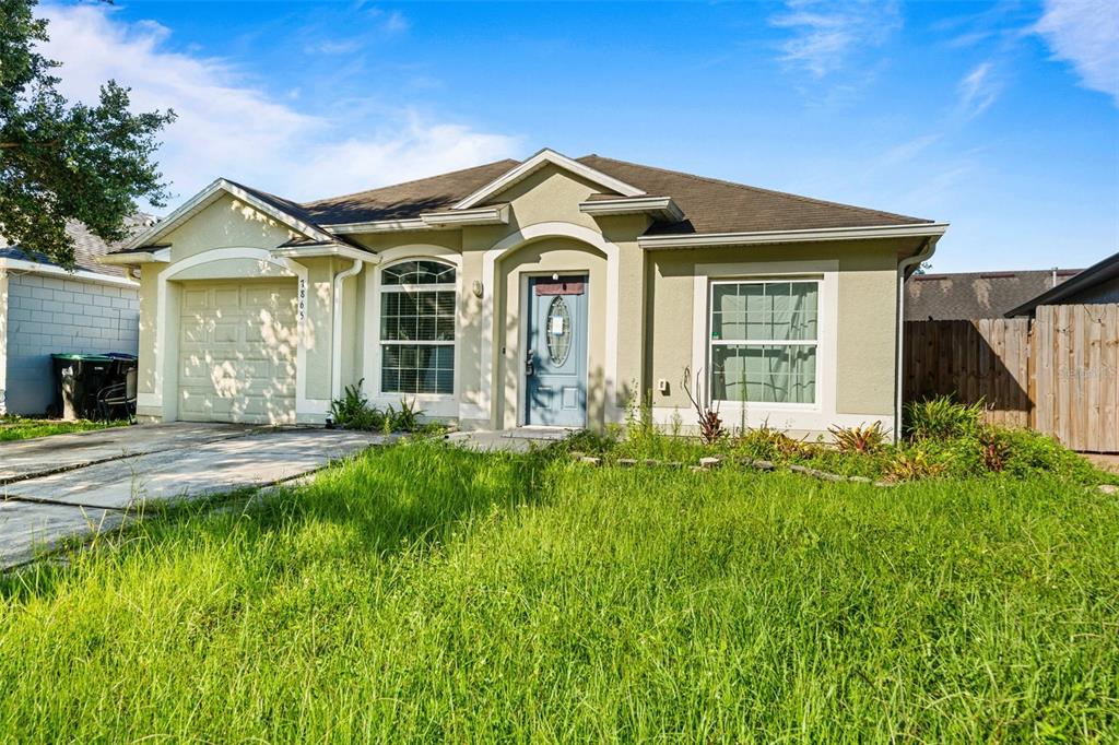 A single-story house with a light-colored stucco exterior, a garage, and an overgrown front lawn — 7865 PINE FORK DRIVE, ORLANDO, FL