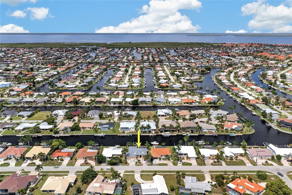 An aerial view shows a residential neighborhood with houses along canals leading to a bay — 959 BAL HARBOR BOULEVARD, PUNTA GORDA, FL