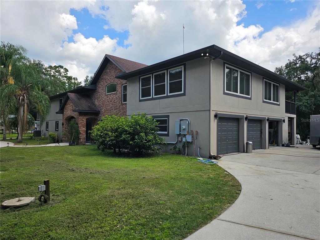 A two-story house with a brick and gray stucco exterior and a three-car garage — 1607 MARTY DRIVE, PIERSON, FL