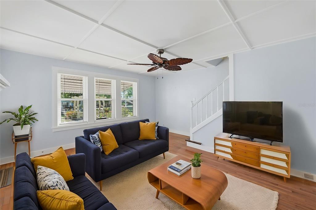 A living room features blue sofas, a wooden coffee table, and a ceiling fan — 10 PLAZA STREET E, BRADENTON, FL
