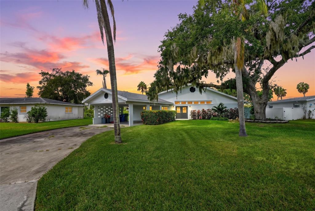 A white house exterior features a gray double door entrance and a manicured green lawn — 341 SHORE DRIVE, ELLENTON, FL