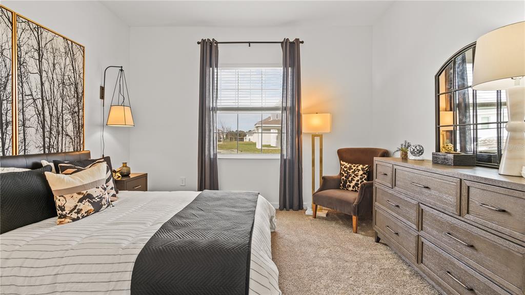 A bedroom features a bed, a dresser with a mirror, an armchair, and a window — 4103 EASTMINSTER ROAD, DAVENPORT, FL