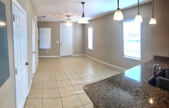 A kitchen island with granite countertops overlooks an open living area with tile flooring — 1102 CHELSEA DRIVE, DAVENPORT, FL