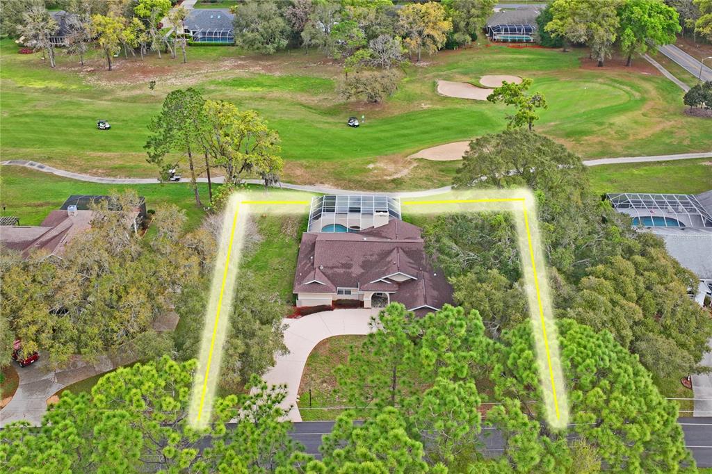 An aerial view shows a house with a pool cage situated on a golf course — 375 E LIBERTY STREET, HERNANDO, FL