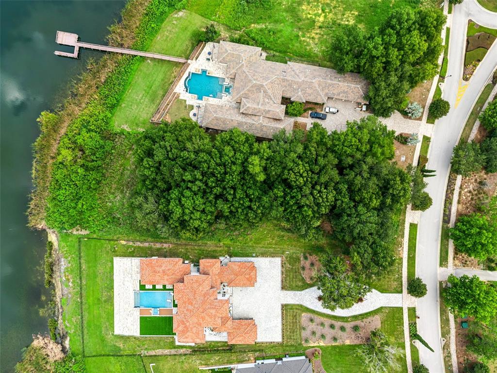 An aerial view shows two waterfront houses with swimming pools, private docks, and wooded lots — 15345 PENDIO DRIVE, MONTVERDE, FL