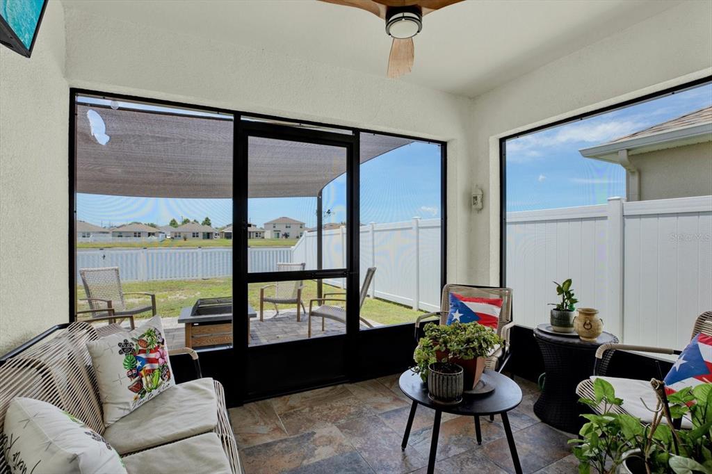 A hallway features a console table with lanterns, a sunburst mirror, and tile flooring — 1013 TIDAL ROCK AVE, RUSKIN, FL