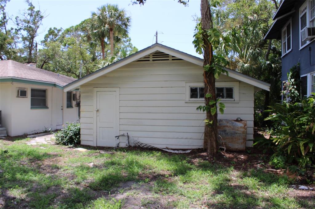 A detached white garage with a side door, small windows, and a gable roof — 300 PRESIDENT STREET, DUNEDIN, FL