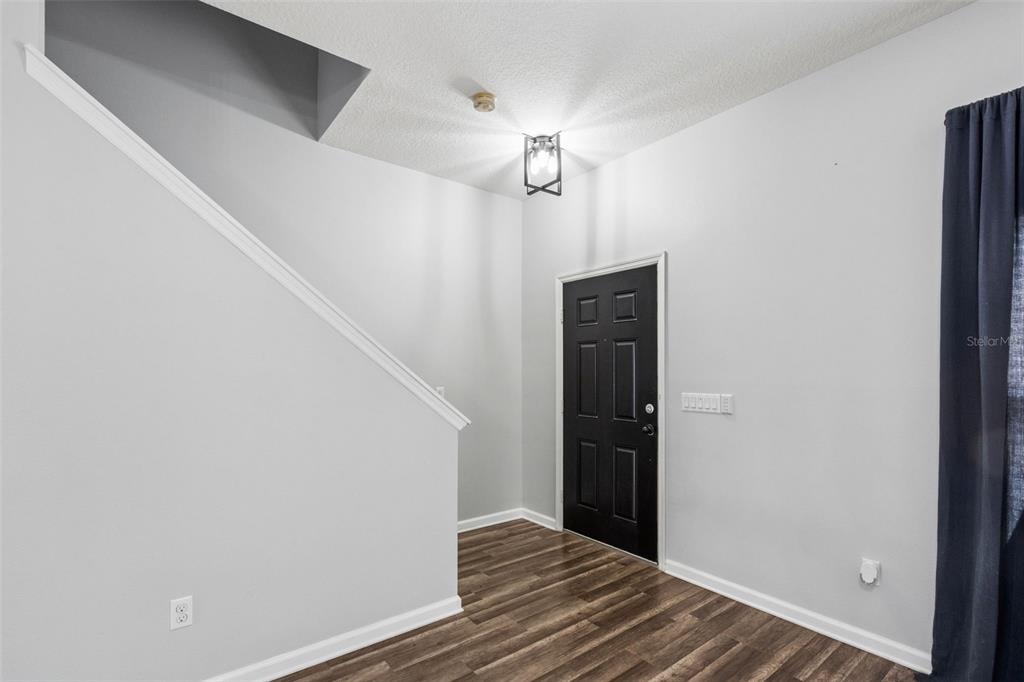 A front porch features a blue door, a metal bench, and a vertical welcome sign — 11843 DEER PATH WAY, ORLANDO, FL