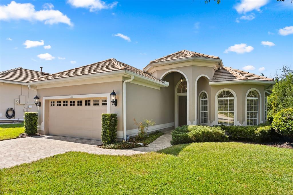 A single-story house with a beige stucco exterior, a two-car garage, and arched windows — 388 SOTHEBY WAY, DEBARY, FL
