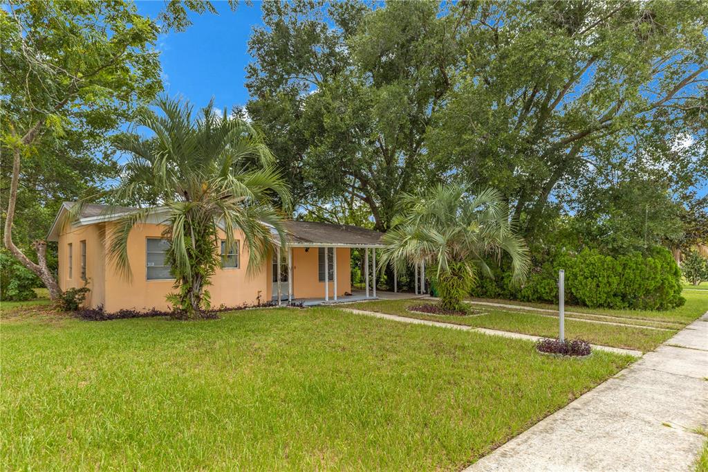 A single-story peach-colored house with a palm tree and a front lawn — 733 HAGER STREET, DELTONA, FL