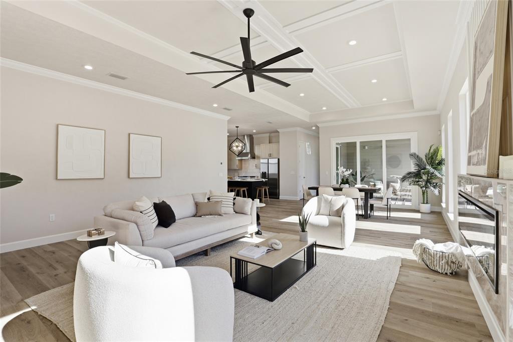 A bright, open-concept living room features light wood flooring, a coffered ceiling, and modern furniture — 13425 SW 9TH ROAD, NEWBERRY, FL