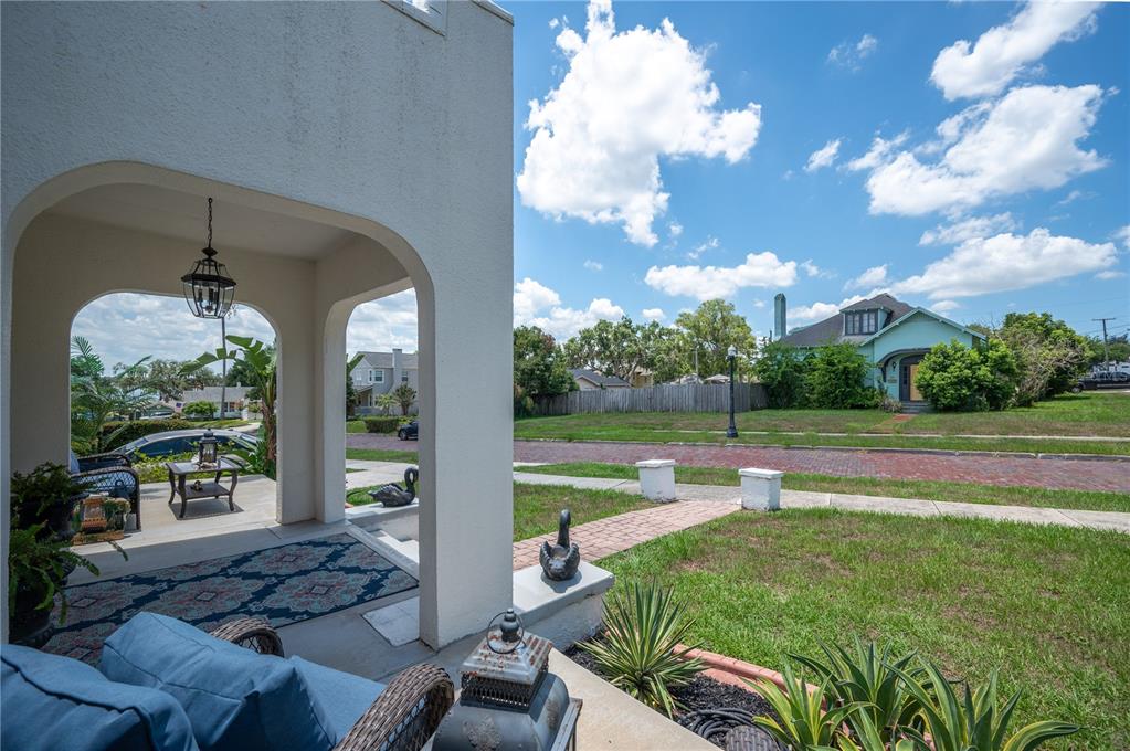 A view from a covered front porch looking out toward a residential street and houses — 1102 MELTON AVENUE, LAKELAND, FL