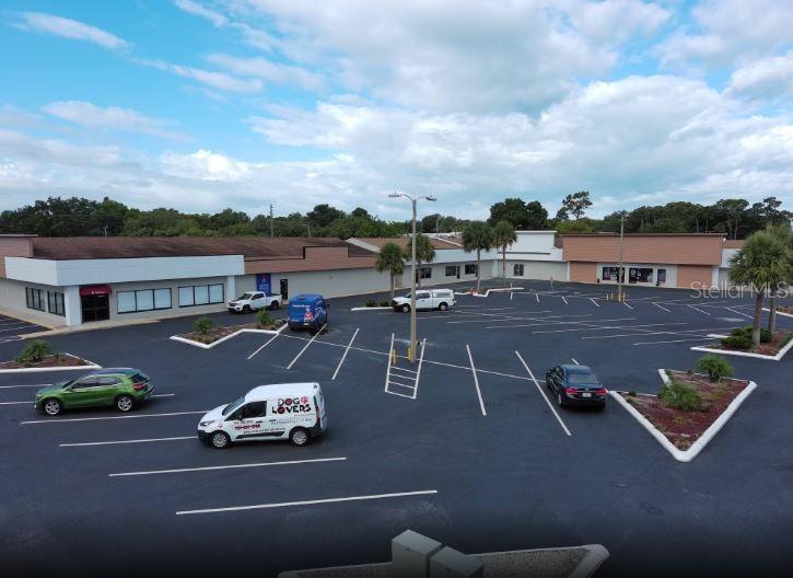 An aerial view of a commercial strip mall with a large paved parking lot — 39930 US HIGHWAY 19 N UNIT 39930, TARPON SPRINGS, FL