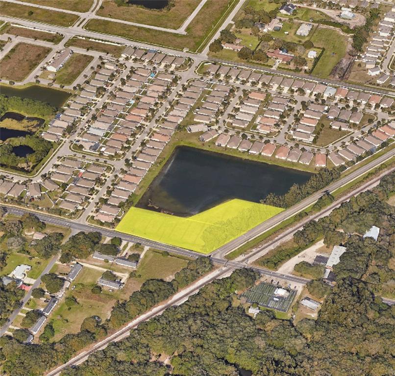 An aerial view shows a vacant, highlighted parcel of land adjacent to a retention pond — 962 E SHELL POINTE ROAD, RUSKIN, FL