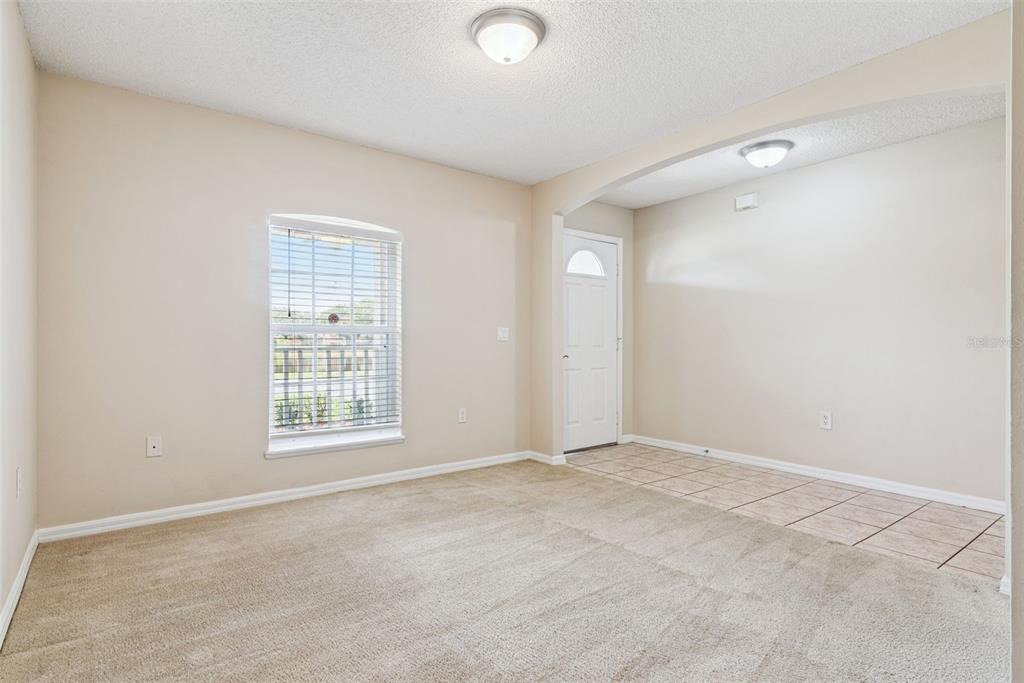 A room with beige carpet, a window with blinds, and a tiled entryway with a door — 3308 ERSKINE DRIVE, ORLANDO, FL