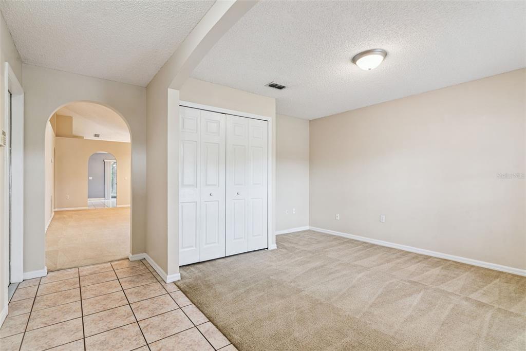 A room with beige carpet, a white closet, and an arched doorway leading to another room — 3308 ERSKINE DRIVE, ORLANDO, FL