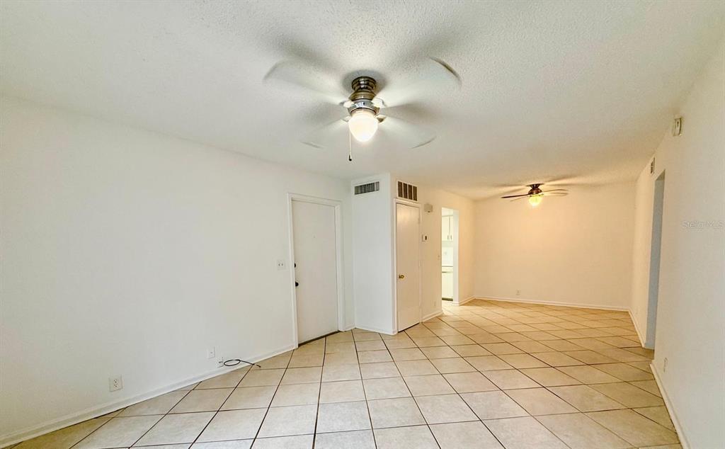 An interior view shows a room with white walls, a tiled floor, and two ceiling fans — 20 SHEOAH BOULEVARD UNIT 9, WINTER SPRINGS, FL