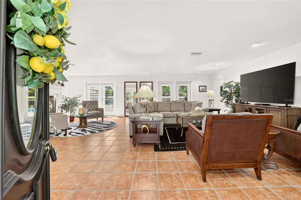 A spacious living room features tile flooring, a large sectional sofa, and a television console — 22 WOOD RIDGE DRIVE, OCALA, FL