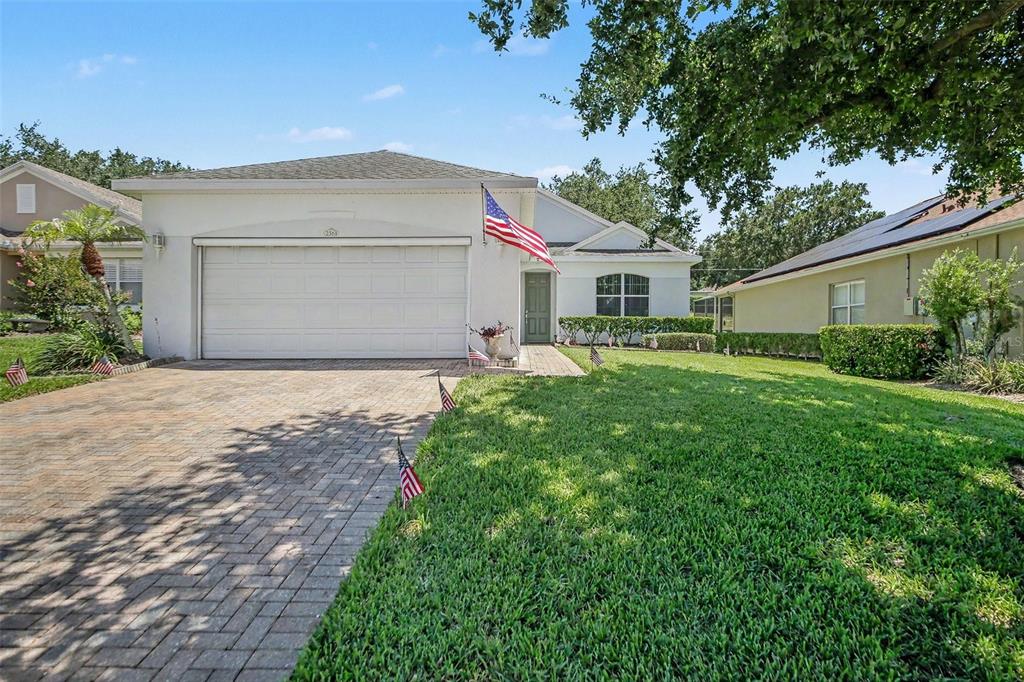 A single-story house with a white exterior, a two-car garage, and a front lawn — 2361 PRAIRIE DUNES, CLERMONT, FL