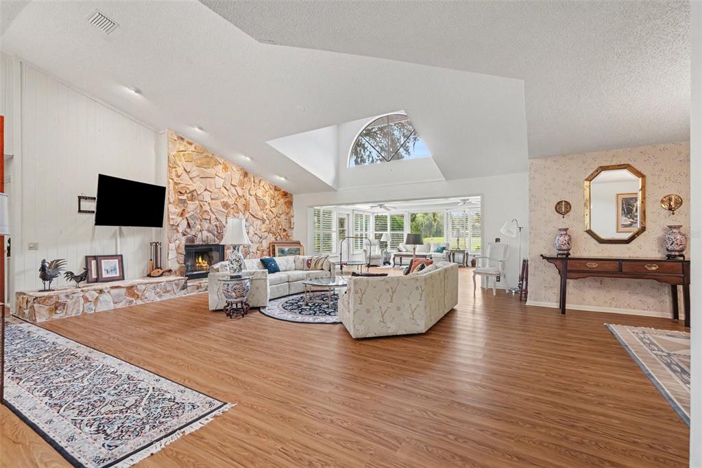 An aerial view shows a house with a gray roof situated behind a pond fountain — 2950 ST ANDREWS BOULEVARD, TARPON SPRINGS, FL