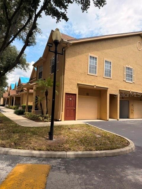 A tan multi-story townhouse exterior features a red front door and a tall street lamp — 877 GRAND REGENCY POINT UNIT 200, ALTAMONTE SPRINGS, FL