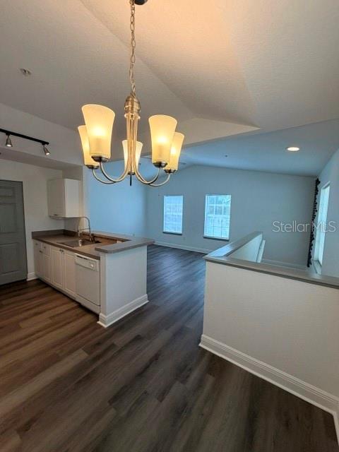 A kitchen with white cabinets and a chandelier overlooks a living area with wood flooring — 877 GRAND REGENCY POINT UNIT 200, ALTAMONTE SPRINGS, FL