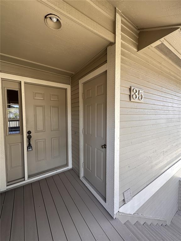 A tan exterior entryway features a front door with a sidelight and a separate side door — 35 MAGNOLIA AVENUE UNIT 35, ORMOND BEACH, FL
