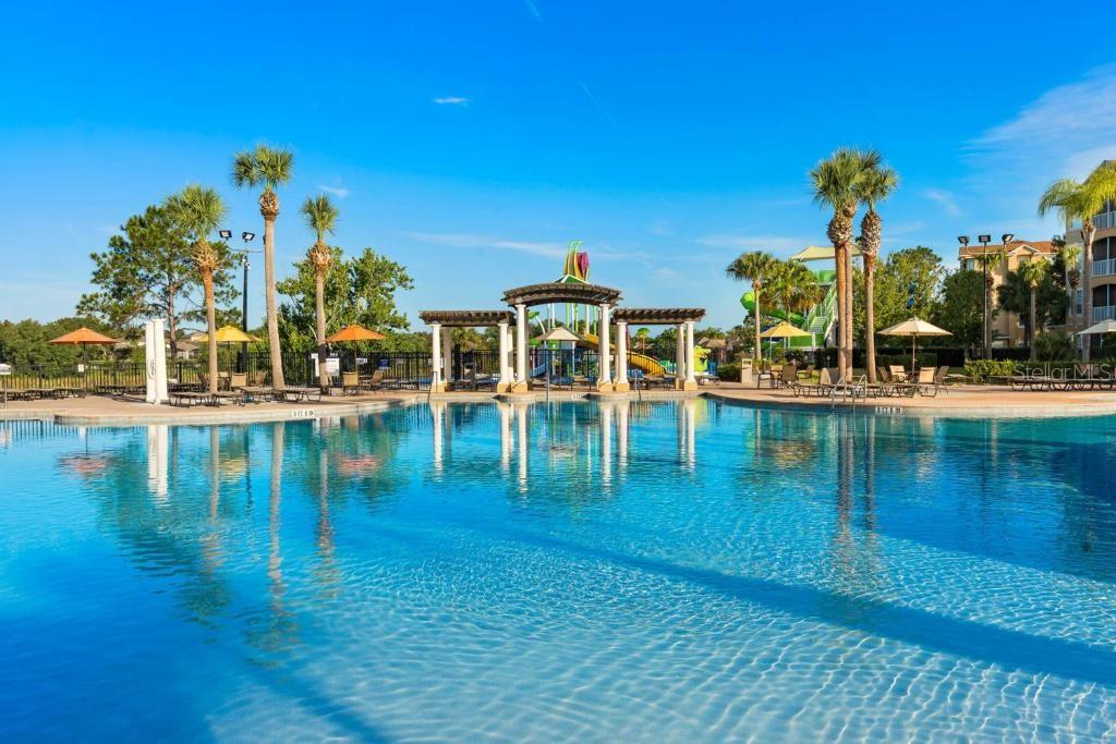 A large swimming pool features a central pergola and water slide under a clear sky — 2817 ALMATON LOOP UNIT 304, KISSIMMEE, FL