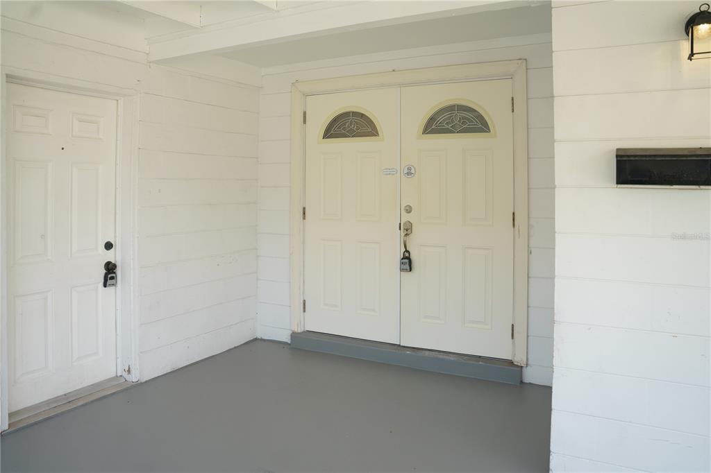 A covered porch features a white double front door and a separate side door — 2804 N 33RD STREET, TAMPA, FL