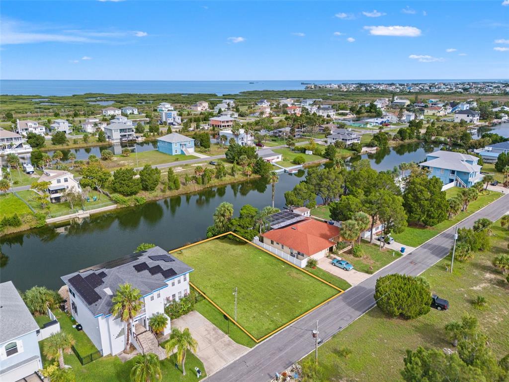 An aerial view shows a vacant residential lot bordered by a canal and neighboring houses — 0 HIBISCUS DRIVE, HERNANDO BEACH, FL
