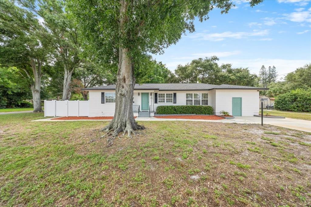 A single-story white house with a teal front door and a concrete driveway — 125 61ST STREET N, ST PETERSBURG, FL