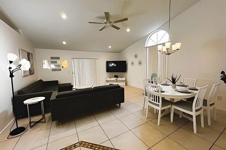 An open-concept living and dining area features tile flooring, a ceiling fan, and neutral walls — 3129 BEAR PATH, KISSIMMEE, FL