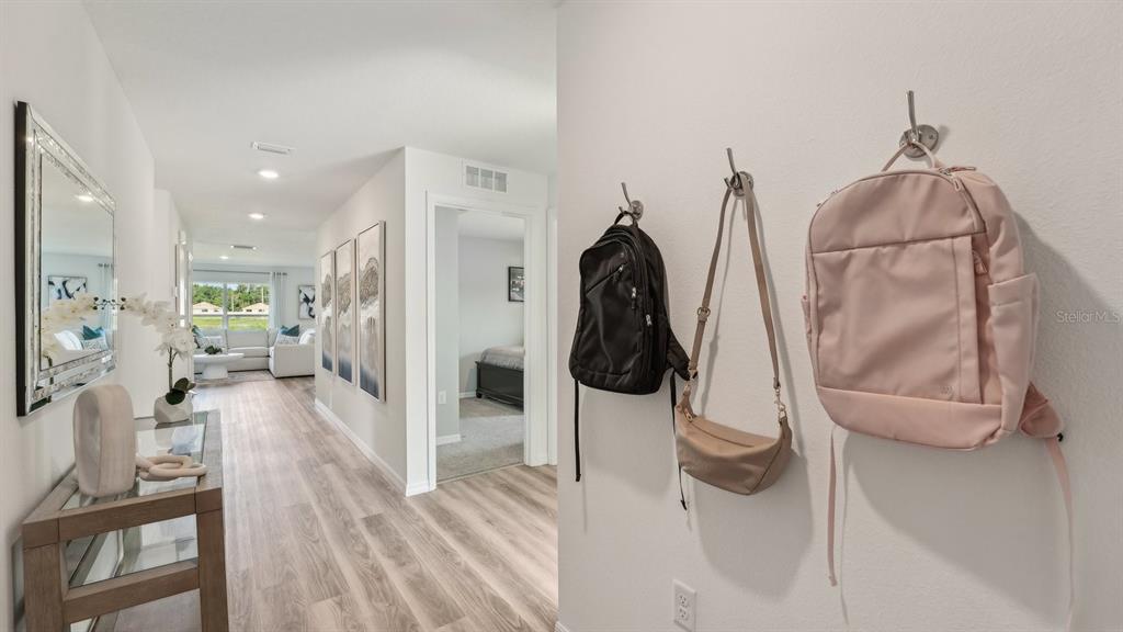 A hallway features light wood flooring, a console table with a mirror, and wall-mounted hooks — 9806 SE 161ST LANE ROAD, SUMMERFIELD, FL