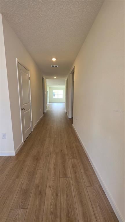 An entryway with light wood-look flooring, three white doors, and a front door with transom — 5851 COOL SPRING COVE, ST CLOUD, FL