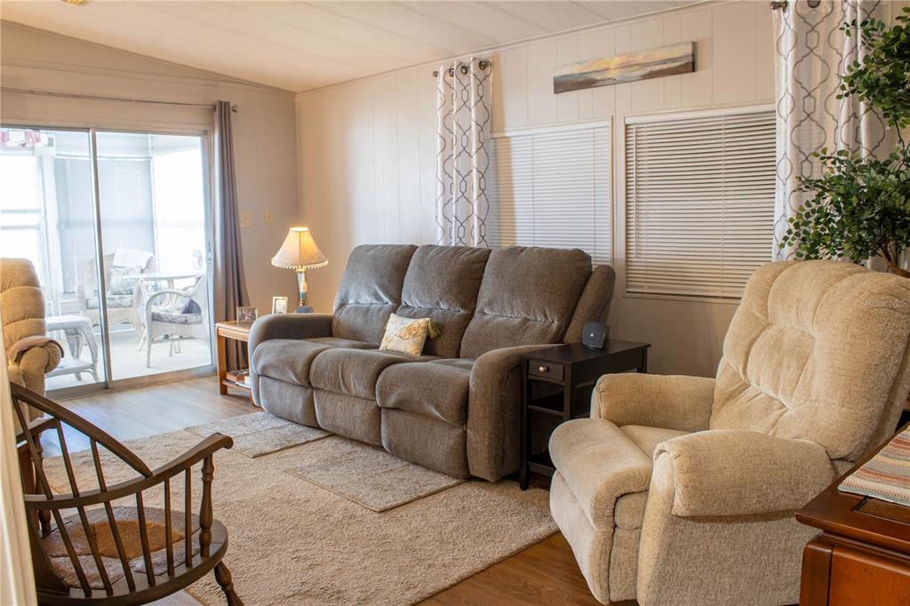 A living room features a gray sofa, a beige recliner, and a sliding glass door — 4332 CHERRYWOOD STREET, WINTER HAVEN, FL