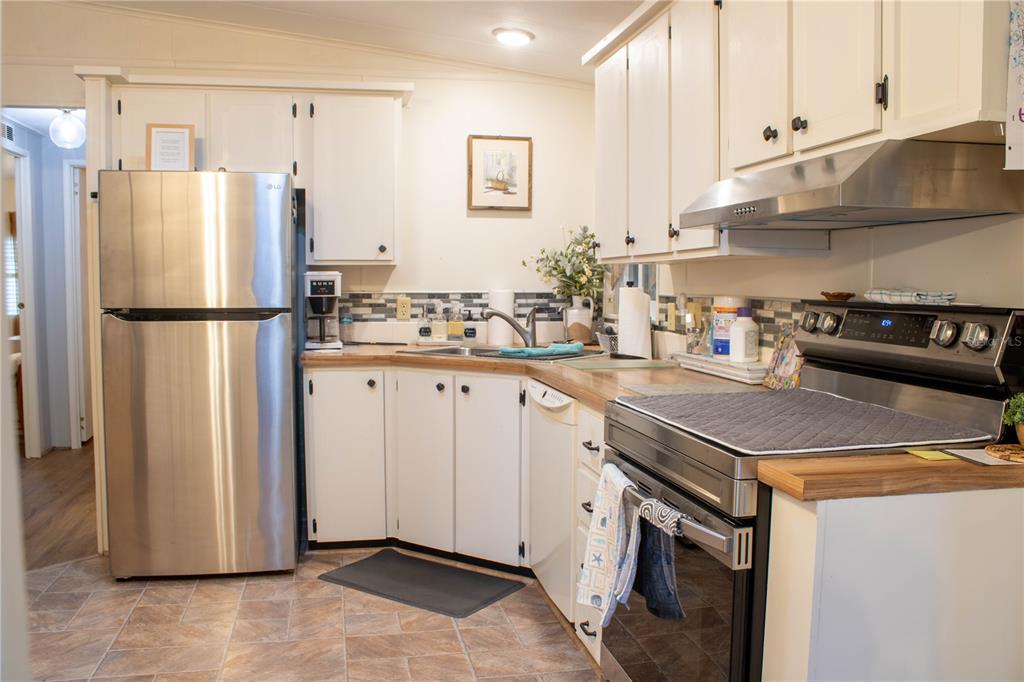 A kitchen with white cabinets, stainless steel appliances, and wood-look countertops — 4332 CHERRYWOOD STREET, WINTER HAVEN, FL