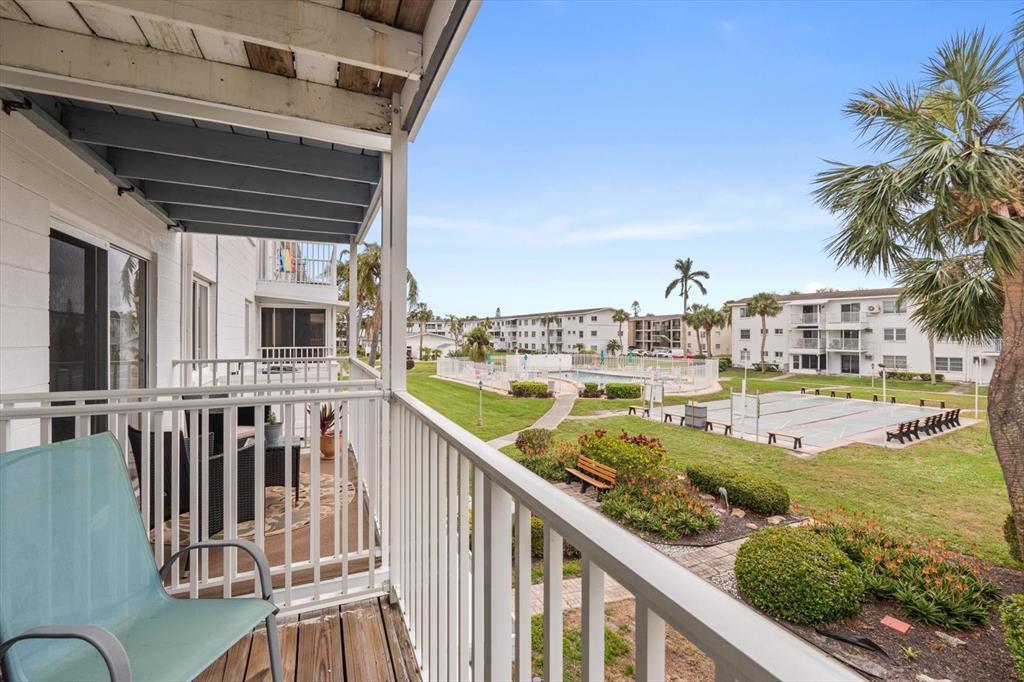 A living room features a sofa, two wicker chairs, a coffee table, and a balcony view — 2326 CANAL DRIVE UNIT G25, BRADENTON, FL