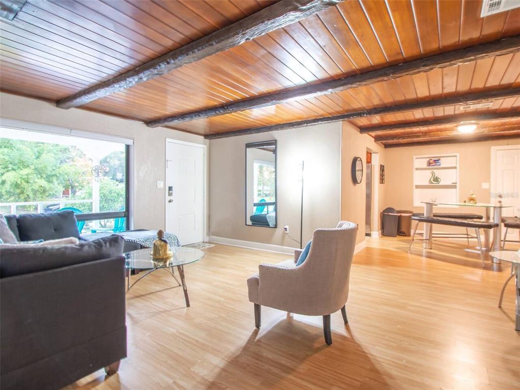 A living room features wood-paneled ceilings with exposed beams, light wood flooring, and a dining area — 1245 CATALPA LANE, ORLANDO, FL